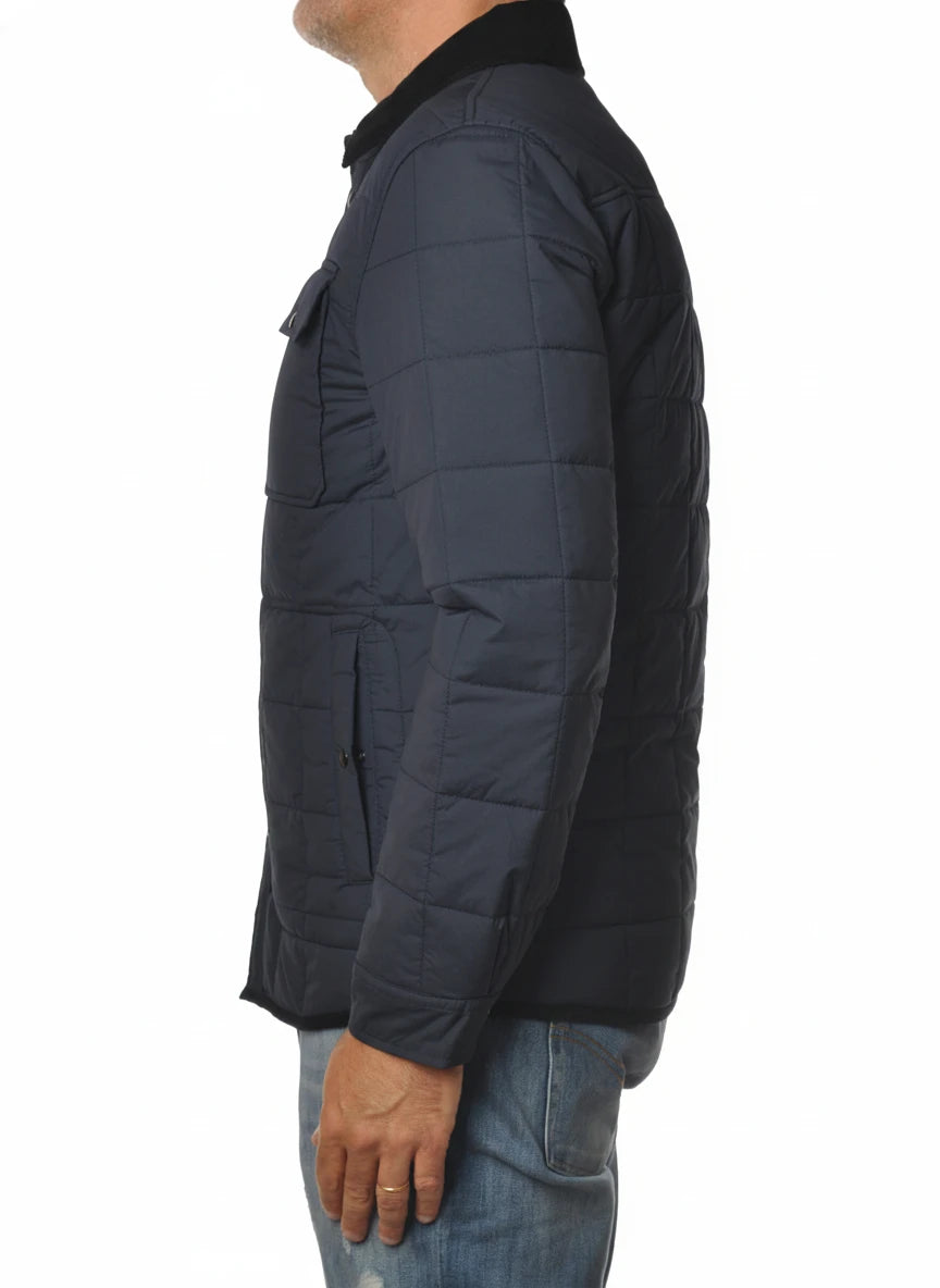 Modello indossa giubbotto blu con collo in velluto e tasca Woolrich ripstop