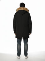 Modello indossa parka nero con cappuccio, pelliccia e toppe Woolrich