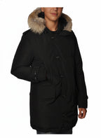 Modello indossa parka nero con cappuccio, pelliccia e toppe Woolrich