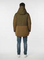 Modello indossa parka verde con cappuccio e tasca Woolrich in tessuto tecnico