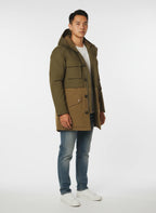 Modello indossa parka verde con cappuccio e tasca Woolrich in tessuto tecnico