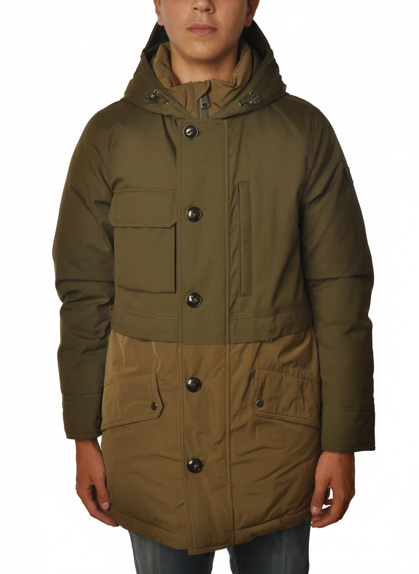 Modello indossa parka verde con cappuccio e tasca Woolrich in tessuto tecnico