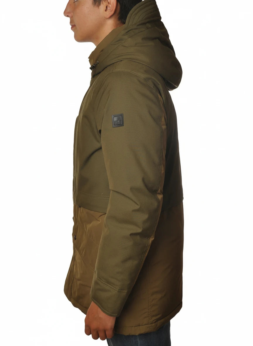 Modello indossa parka verde con cappuccio e tasca Woolrich in tessuto tecnico