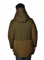 Modello indossa parka verde con cappuccio e tasca Woolrich in tessuto tecnico