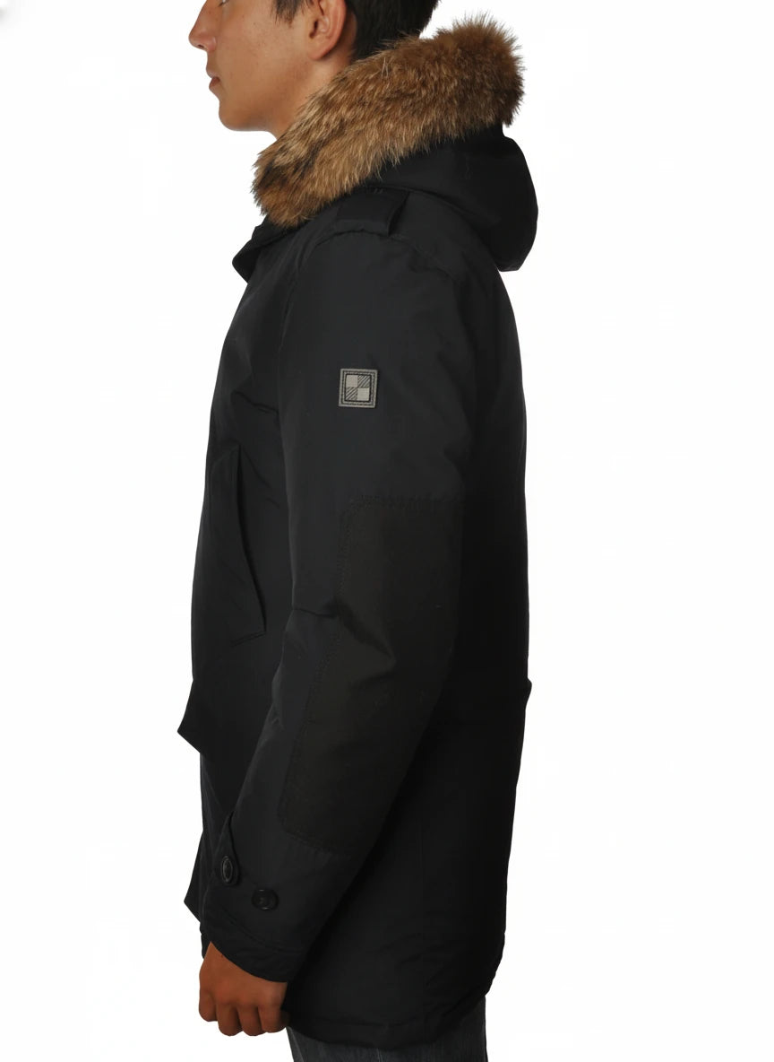 Modello indossa parka blu con cappuccio, pelliccia e toppe Woolrich