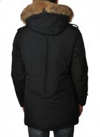 Modello indossa parka blu con cappuccio, pelliccia e toppe Woolrich