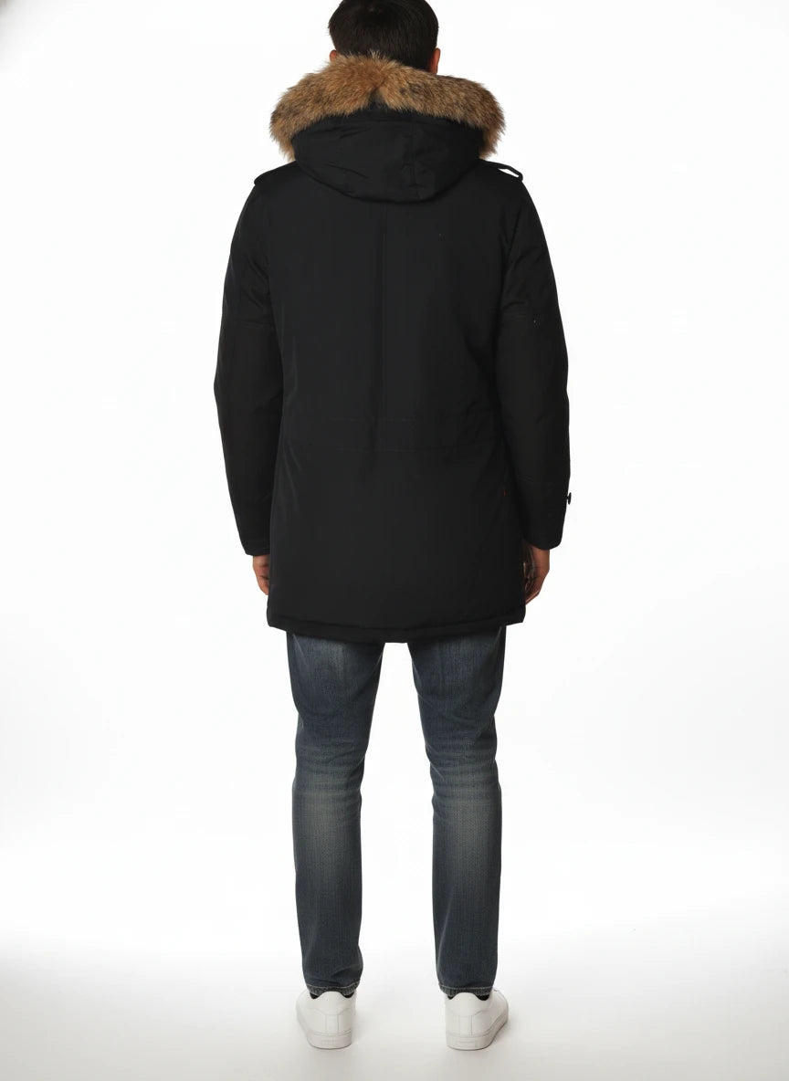 Modello indossa parka blu con cappuccio, pelliccia e toppe Woolrich