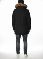 Modello indossa parka blu con cappuccio, pelliccia e toppe Woolrich