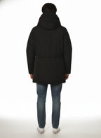 Modello indossa parka nero con cappuccio e tasca Woolrich in tessuto tecnico