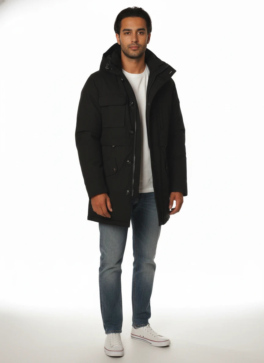 Modello indossa parka nero con cappuccio e tasca Woolrich in tessuto tecnico