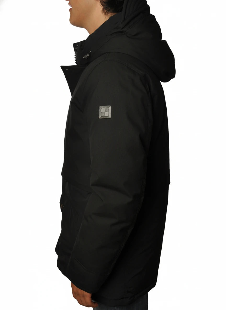 Modello indossa parka nero con cappuccio e tasca Woolrich in tessuto tecnico
