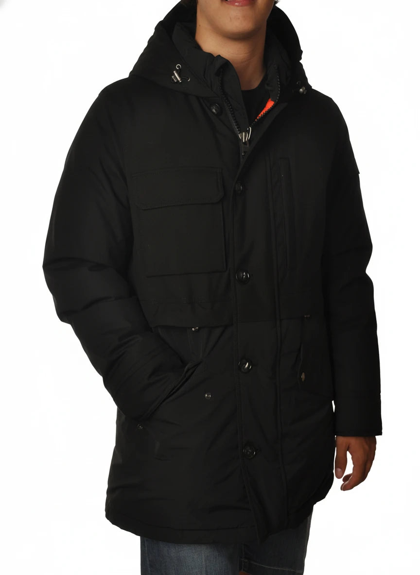 Modello indossa parka nero con cappuccio e tasca Woolrich in tessuto tecnico