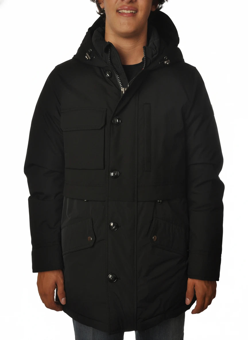 Modello indossa parka nero con cappuccio e tasca Woolrich in tessuto tecnico