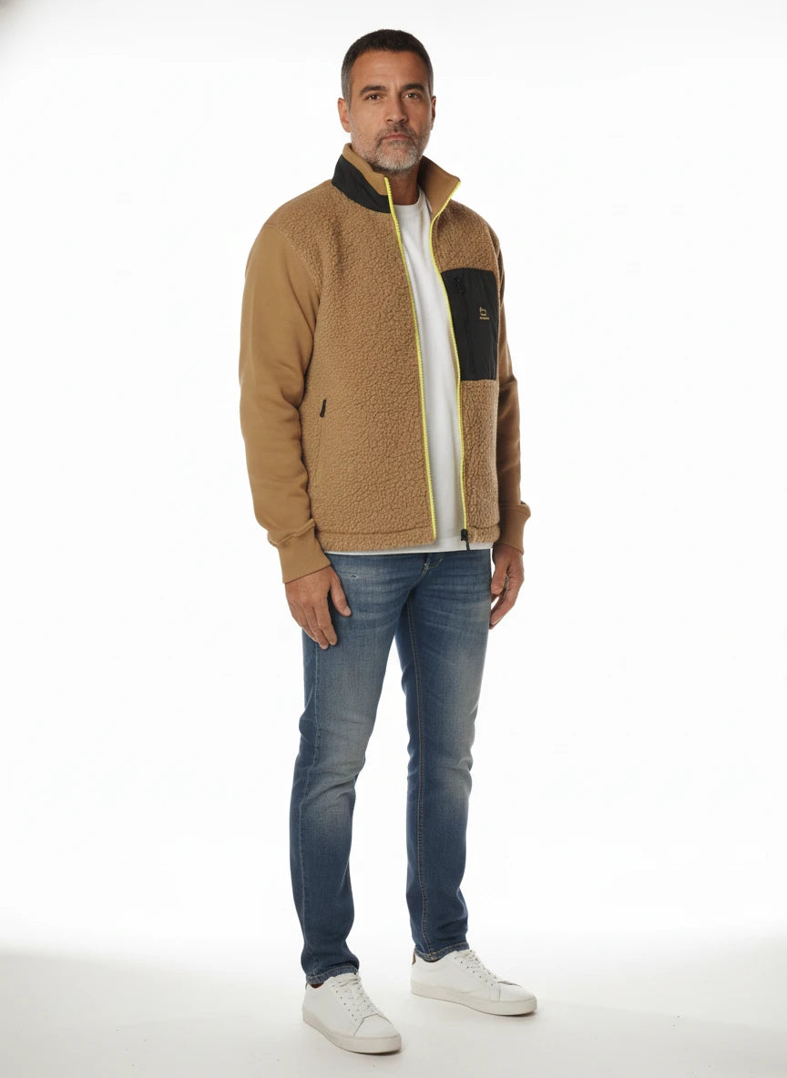 Modello indossa felpa beige con parte in lana e zip fluo Woolrich