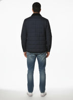 Modello indossa giubbotto blu con collo in velluto e tasca Woolrich ripstop