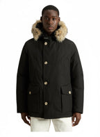 Modello indossa anorak nero in Ramar Cloth con pelliccia di coyote Woolrich