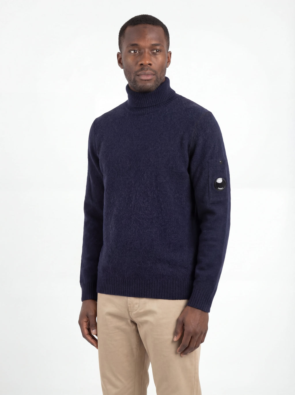 Modello indossa maglia collo alto blu C.P. Company da uomo in primo piano