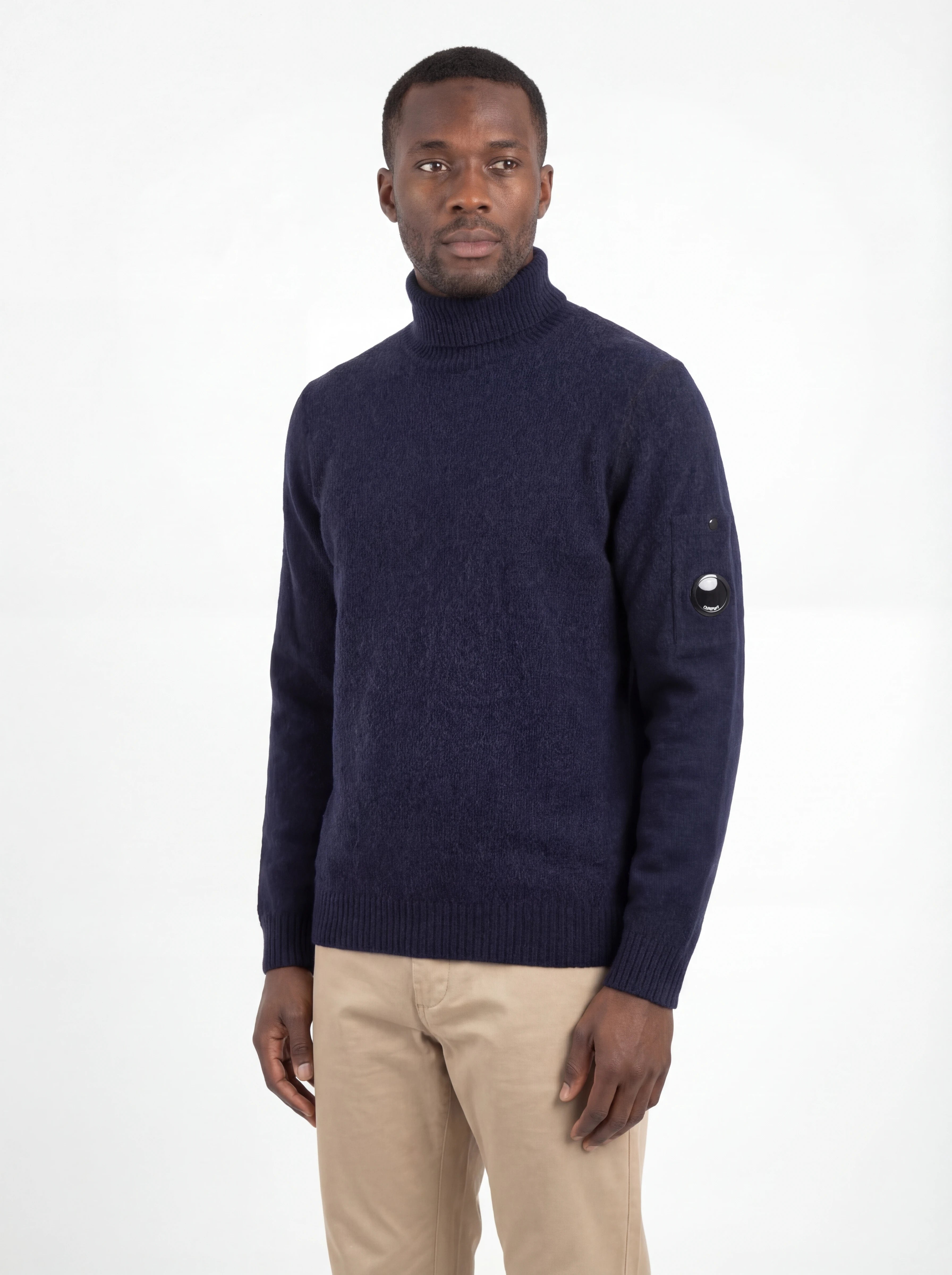 Modello indossa maglia collo alto blu C.P. Company da uomo in primo piano