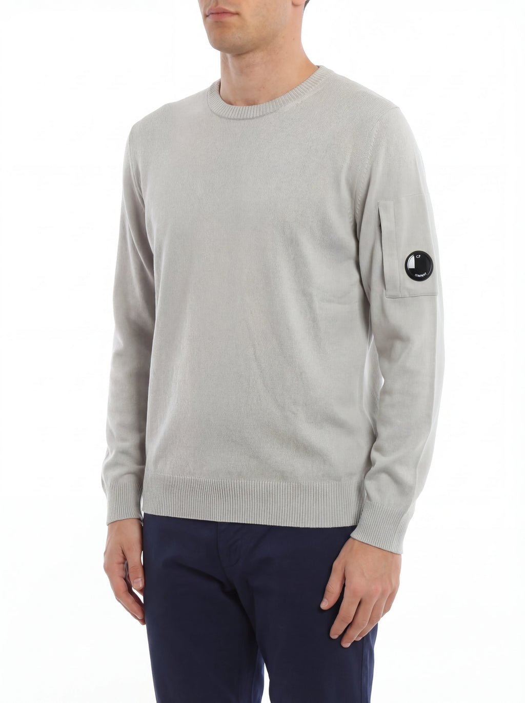 Modello indossa maglia girocollo grigio perla taschino con lente taschino C.P. Company da uomo in cotone