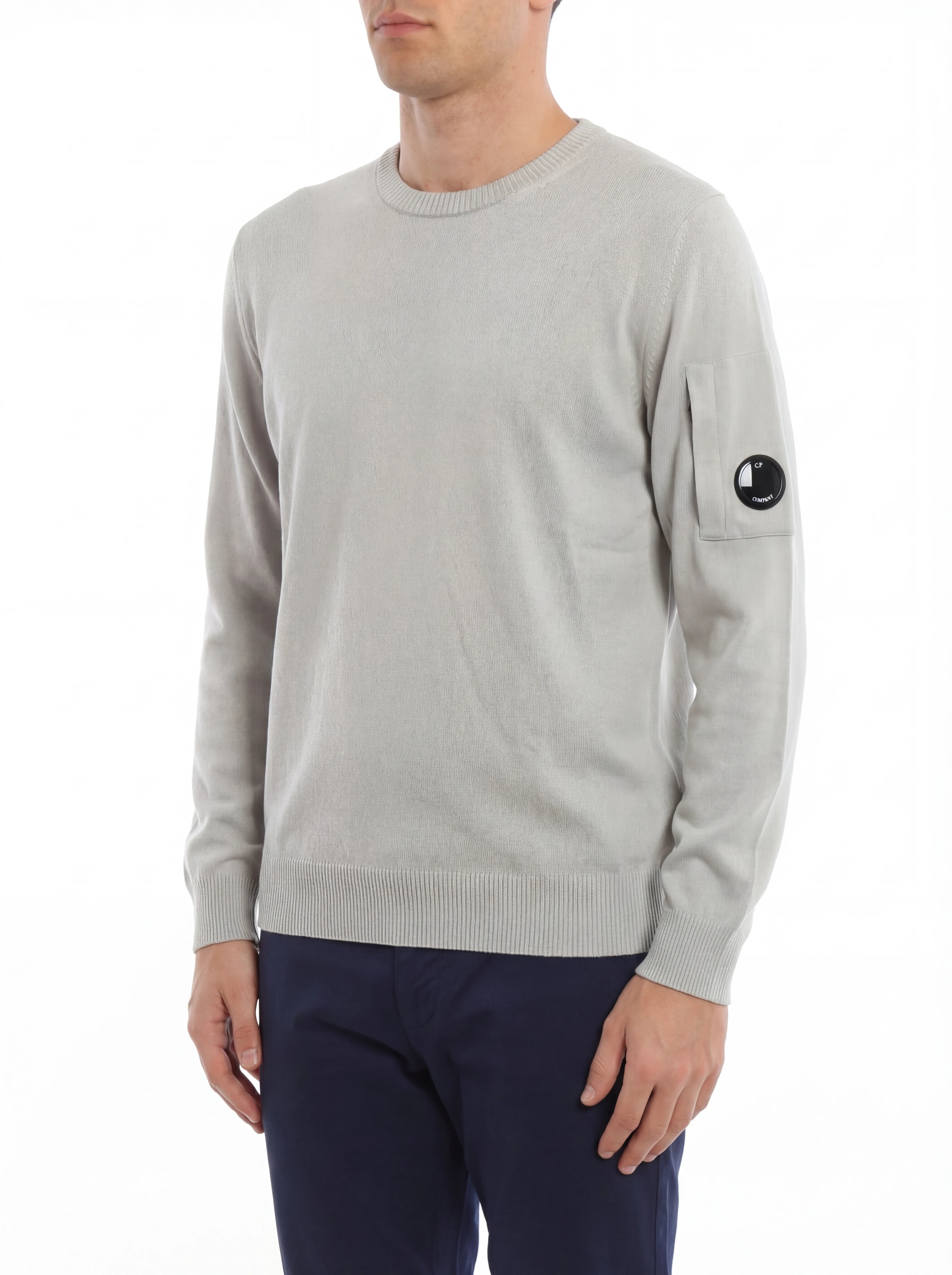 Modello indossa maglia girocollo grigio perla taschino con lente taschino C.P. Company da uomo in cotone
