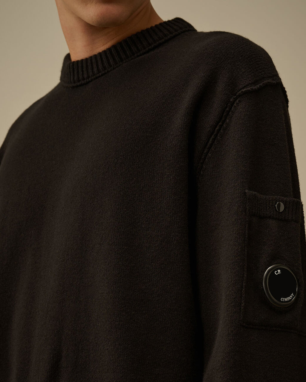 Close-up dettagli, maglia girocollo nero taschino con lente taschino C.P. Company da uomo in cotone