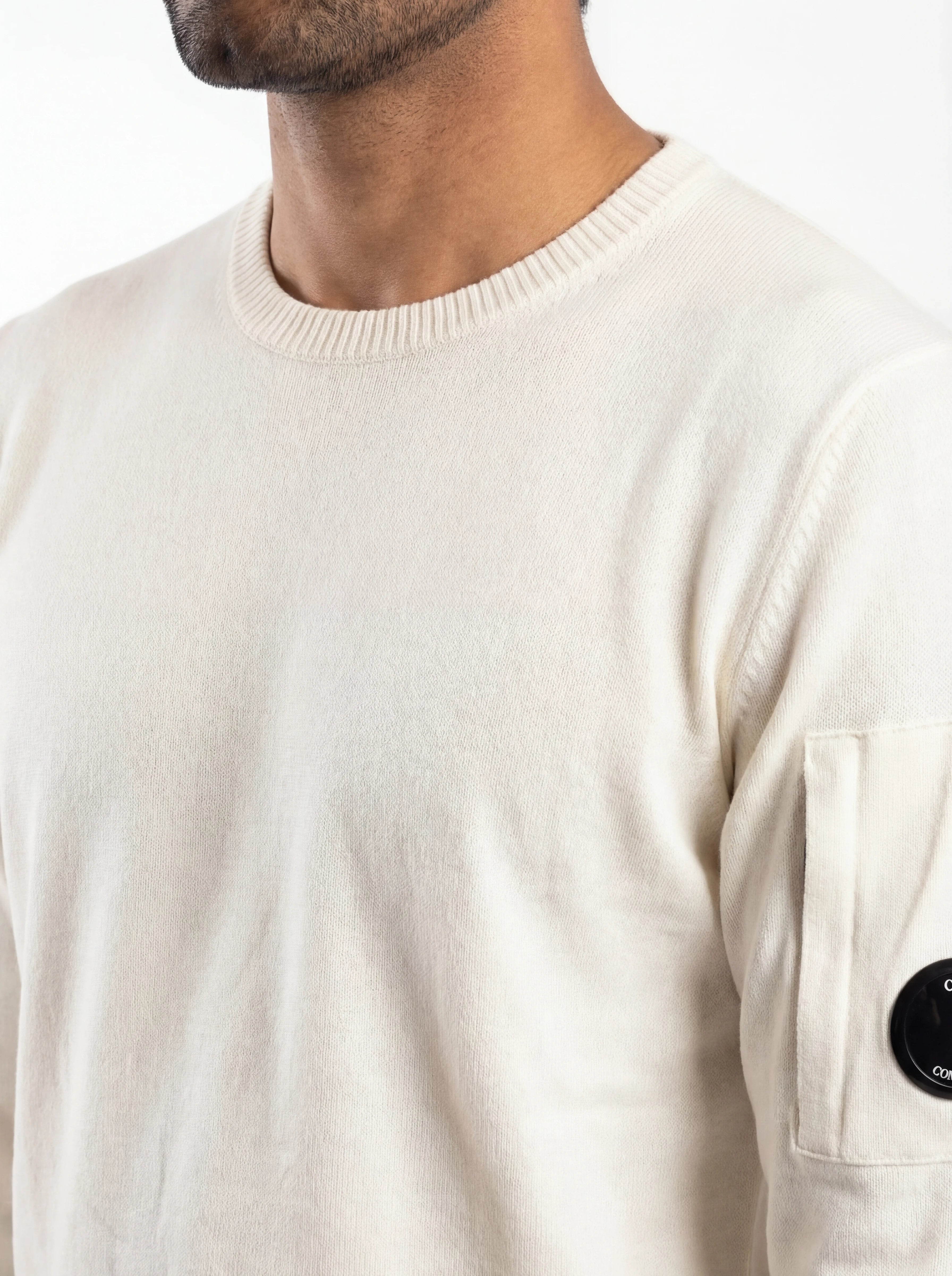 Vista da dietro, modello con maglione bianco taschino con lente taschino C.P. Company da uomo in cotone