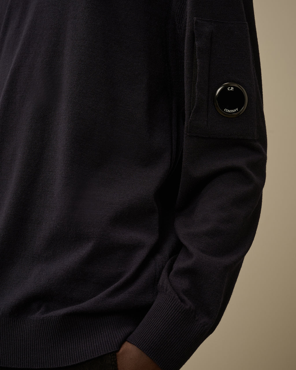 Vista da dietro, modello con maglia girocollo blu taschino con lente taschino C.P. Company da uomo in lana merino extrafine