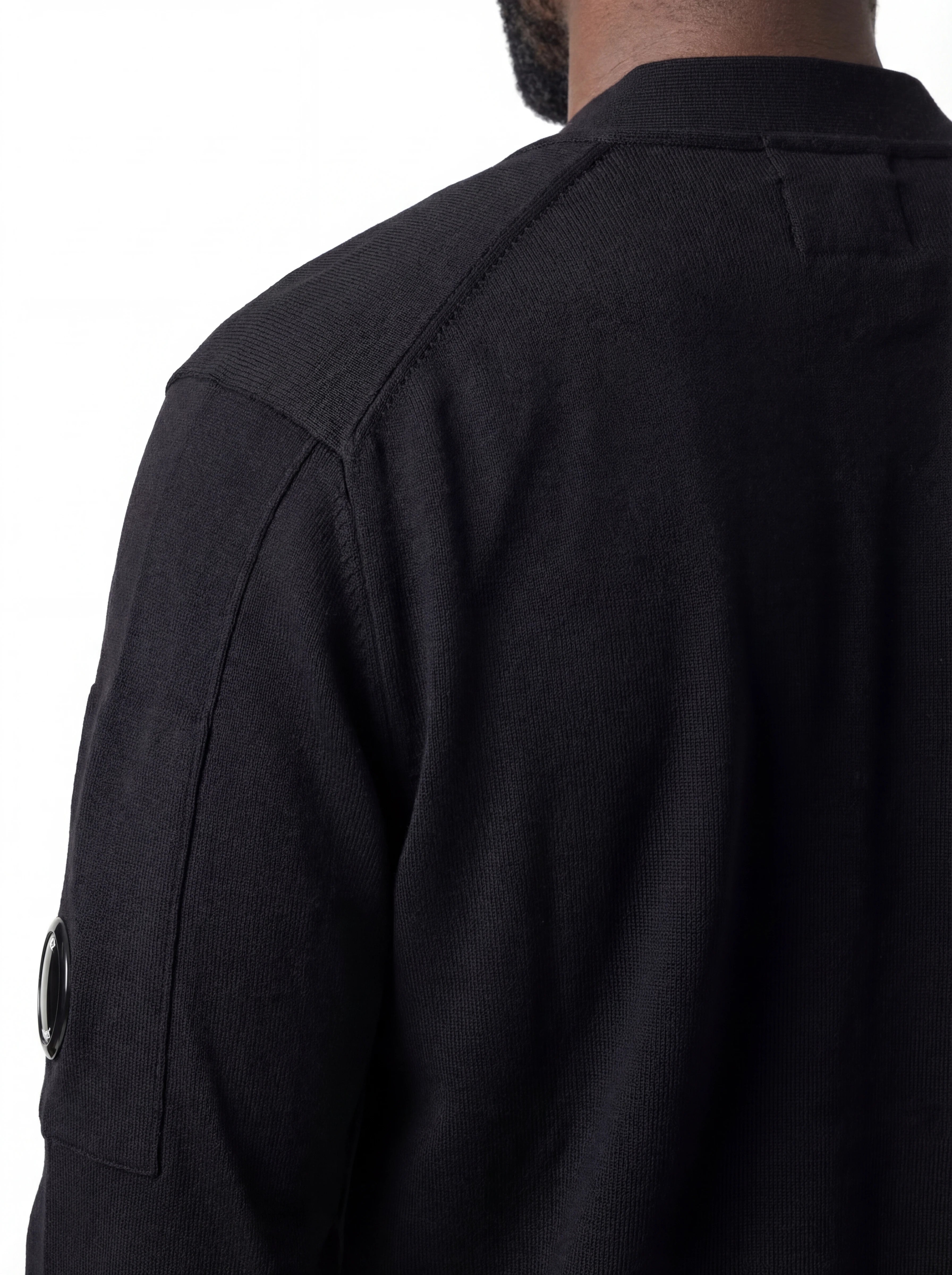 Vista da dietro, modello con cardigan nero taschino manica a rilievo C.P. Company da uomo