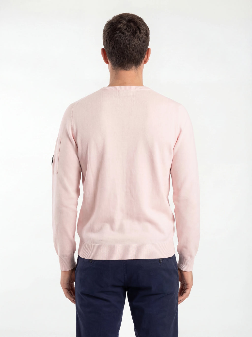 Vista da dietro, modello con maglia girocollo rosa taschino con lente taschino C.P. Company da uomo in cotone