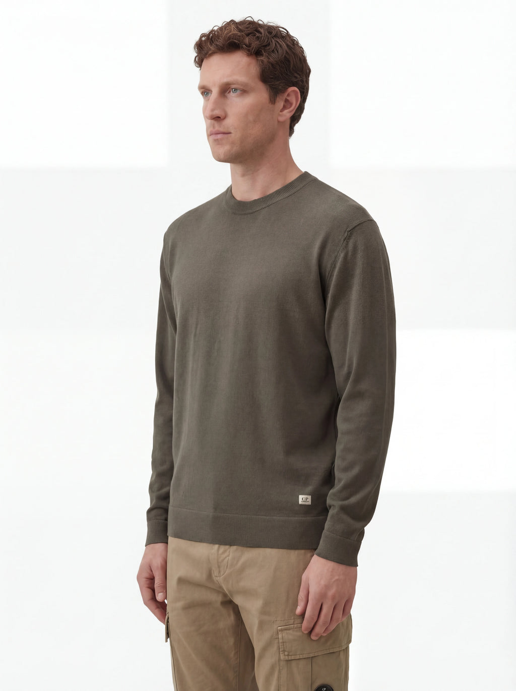 Modello indossa maglia girocollo grigio scuro C.P. Company da uomo