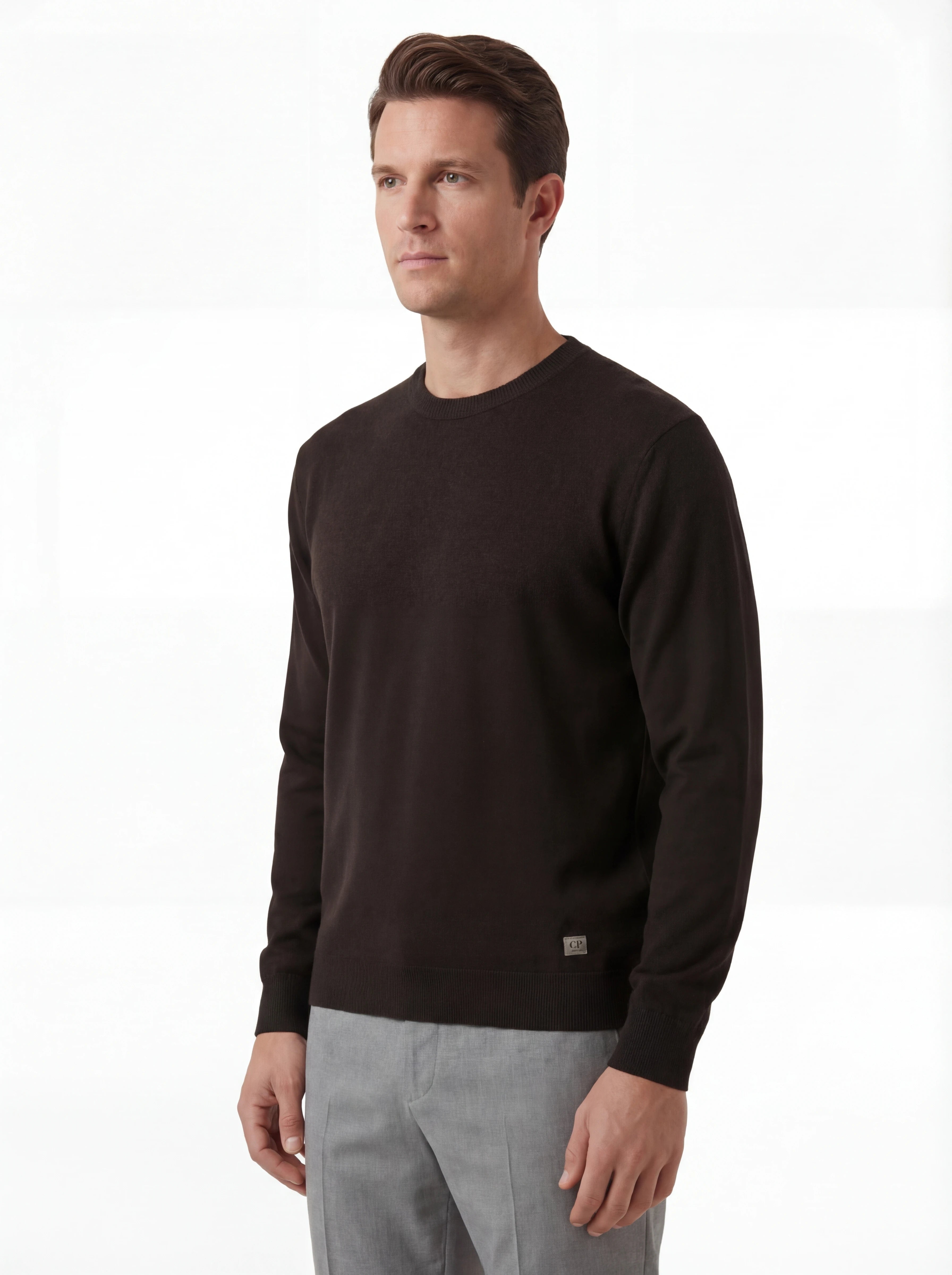 Modello indossa maglia girocollo nero a costine cuciture a contrasto C.P. Company da uomo in lana merino