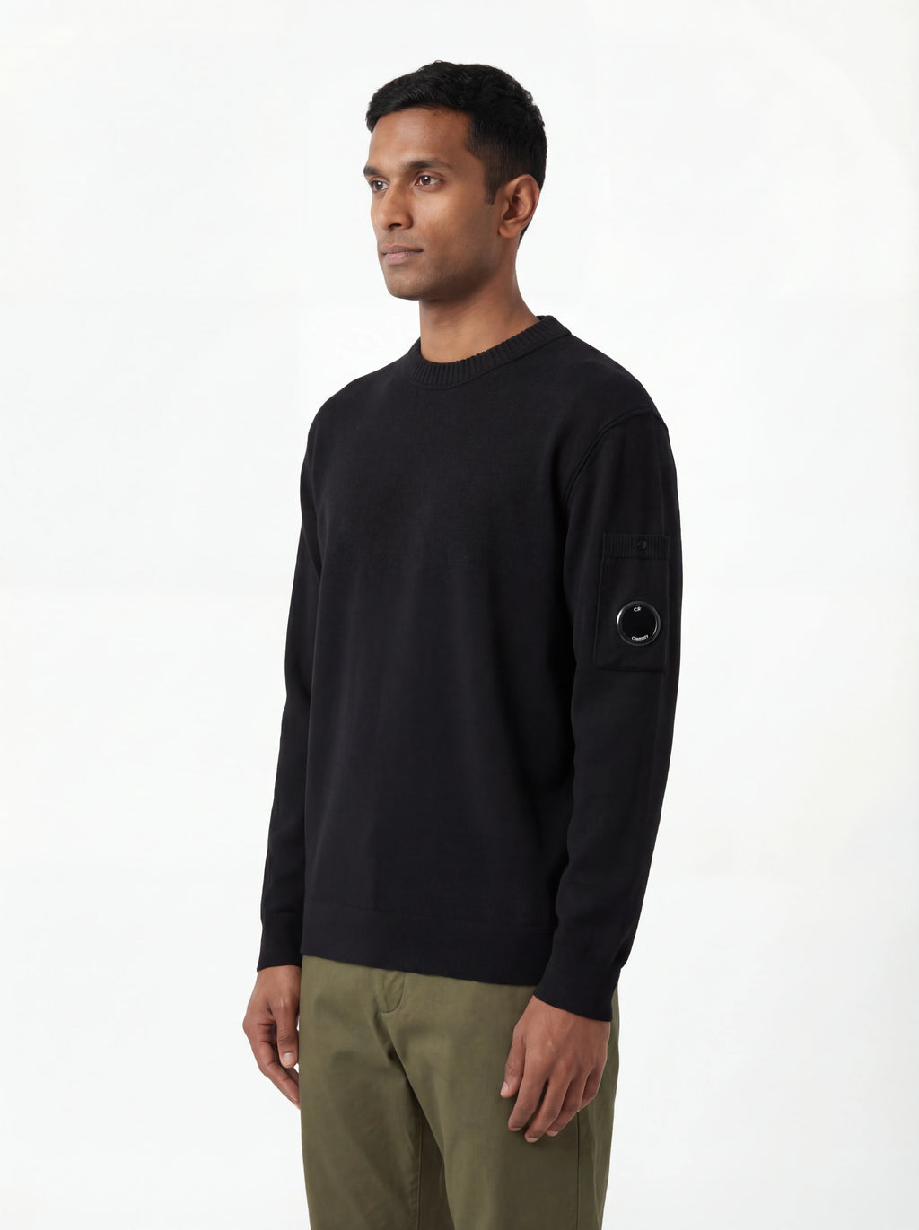 Modello indossa maglia girocollo nero taschino con lente taschino C.P. Company da uomo in cotone