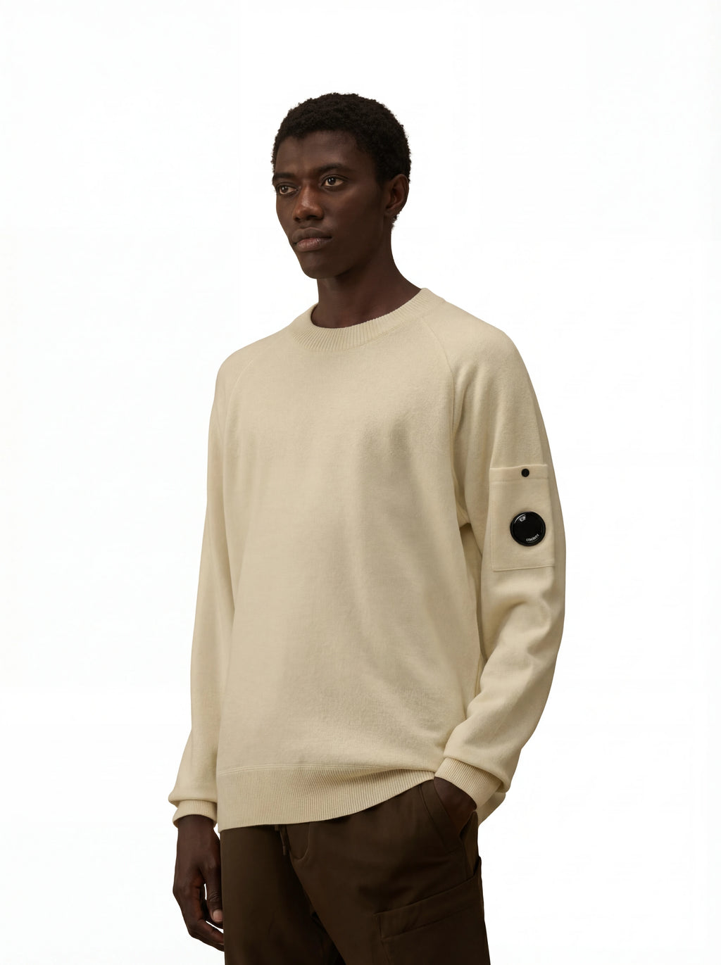 Modello indossa maglia girocollo panna taschino con lente taschino C.P. Company da uomo in lana merino