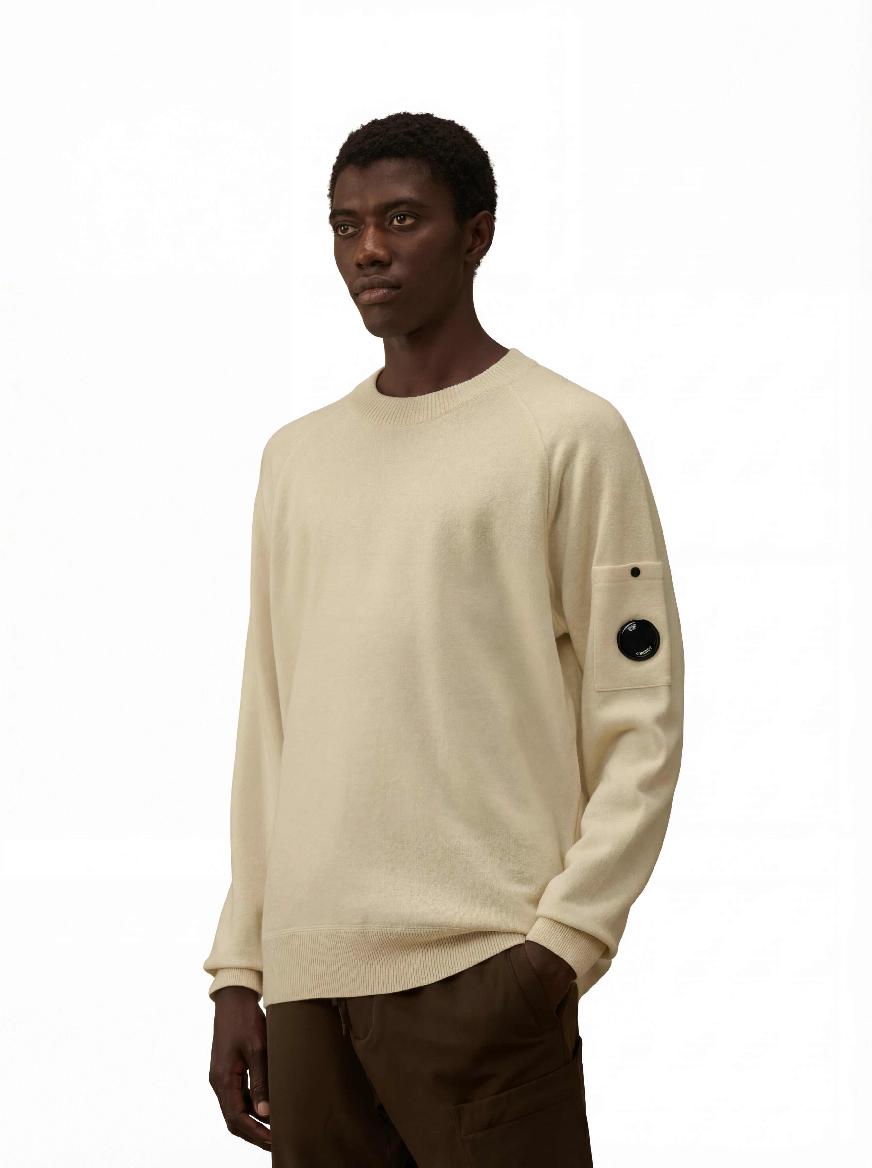 Modello indossa maglia girocollo panna taschino con lente taschino C.P. Company da uomo in lana merino