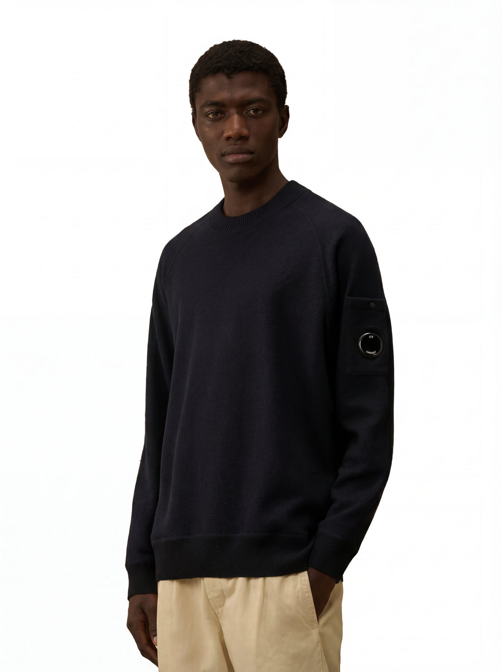 Modello indossa maglia girocollo blu taschino con lente taschino C.P. Company da uomo in lana merino