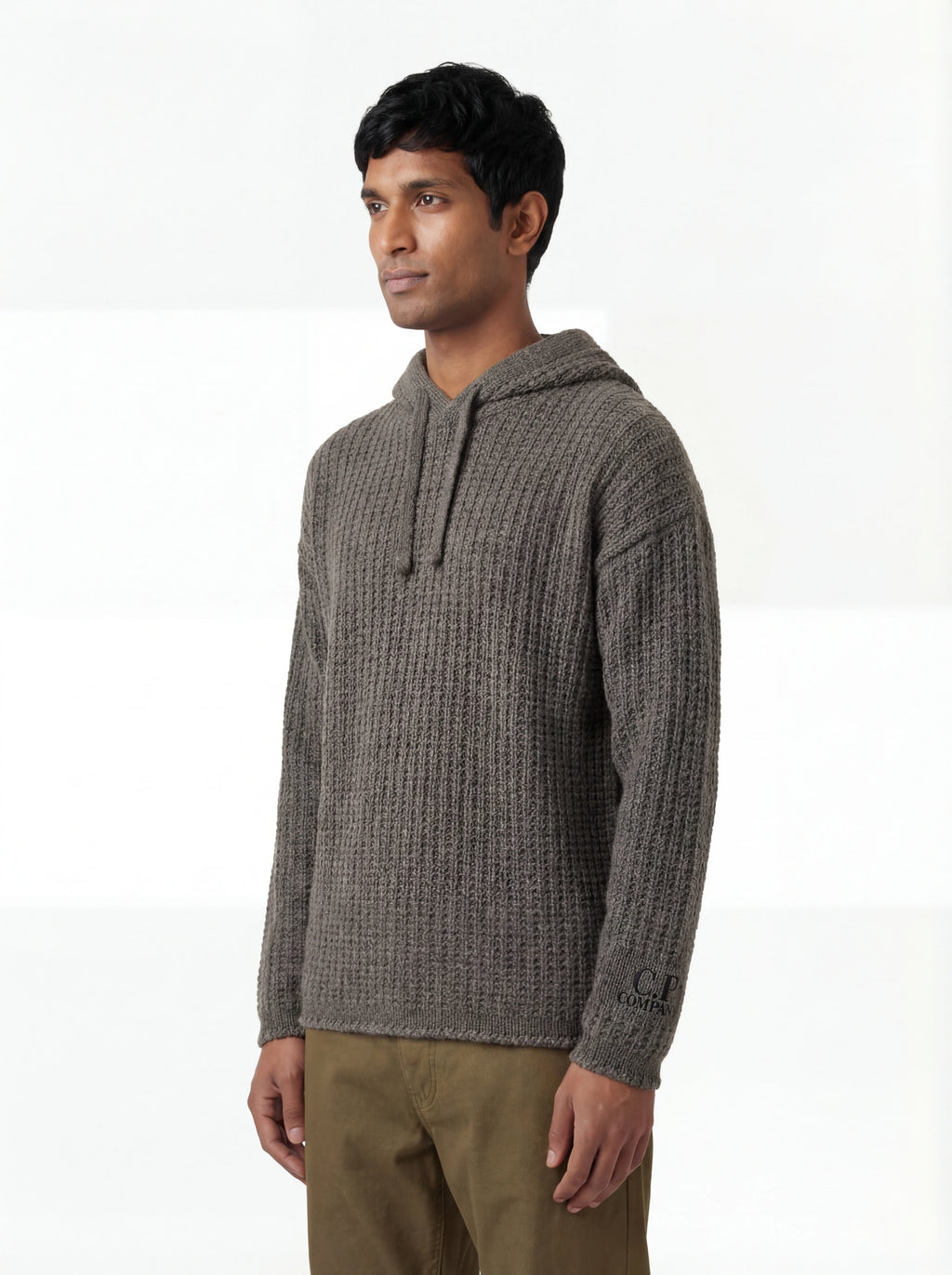 Modello indossa maglione grigio cappuccio C.P. Company da uomo in lana