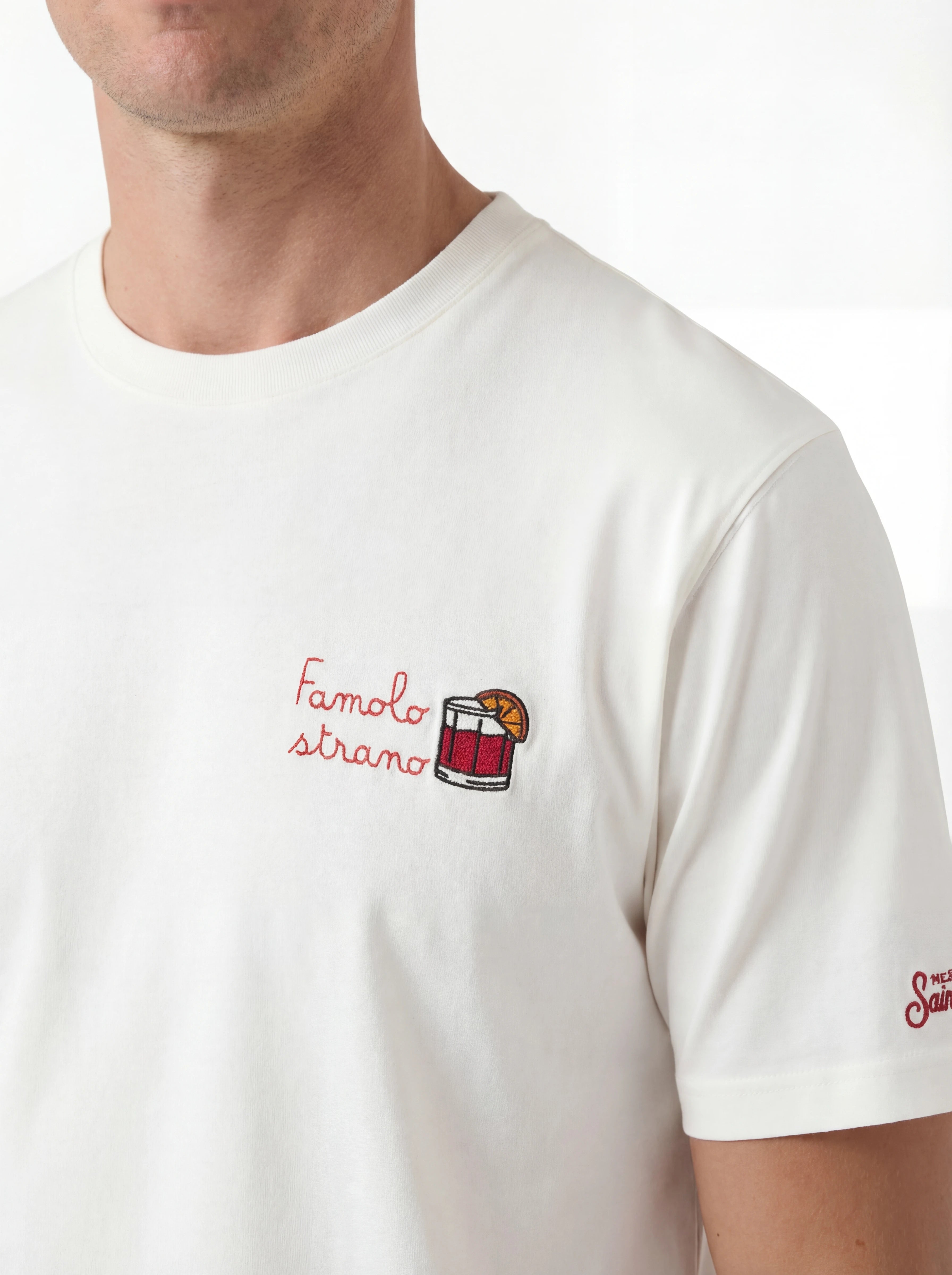 T-shirt su sfondo neutro da dietro t-shirt bianco scritta “Famolo Strano” Saint Barth cotone